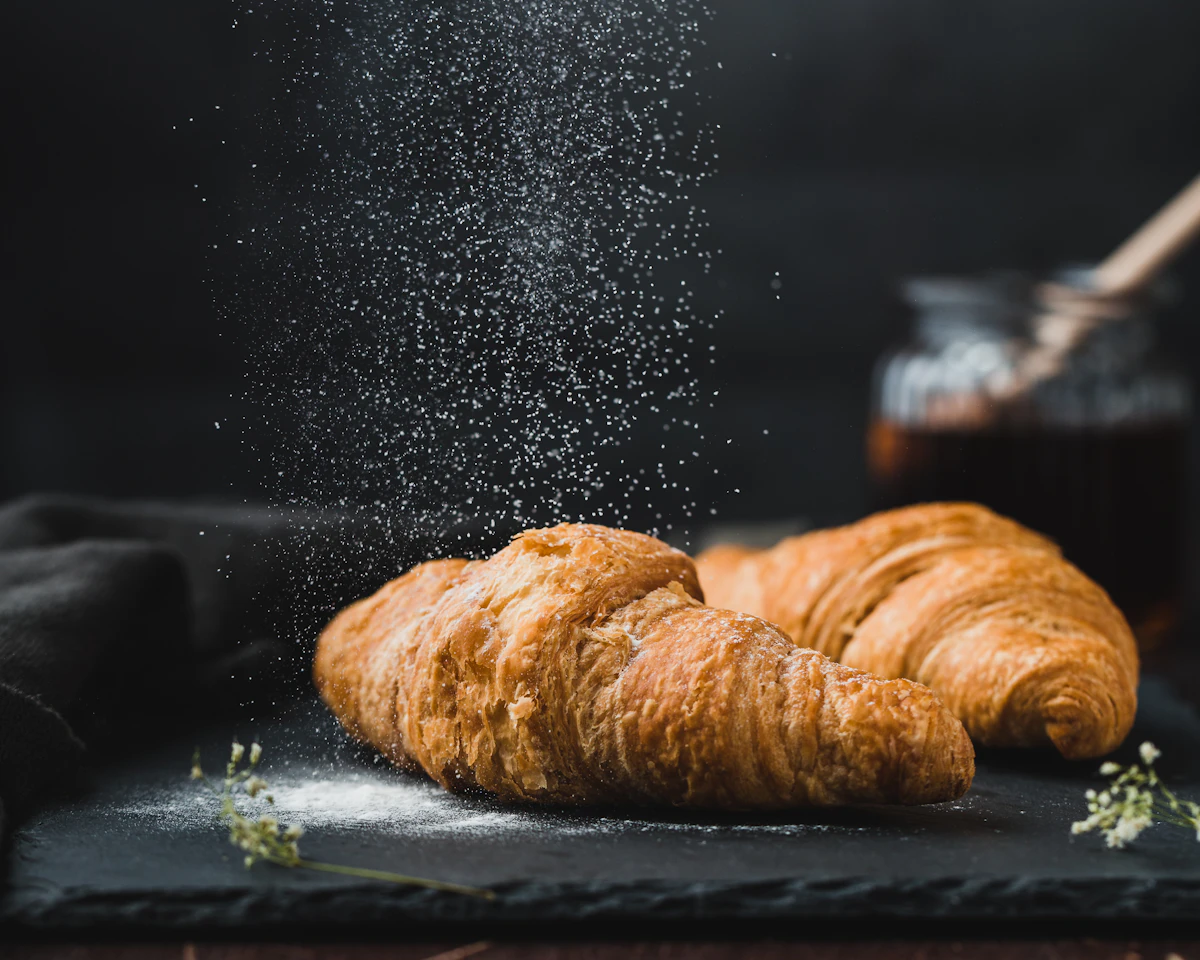 Fresh sourdough loaves and trays of golden baklava on a wooden bakery counter